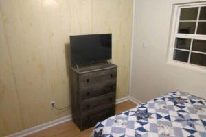 a bedroom with a tv on a dresser with a bed at Kingston Station - 4 in Kingston