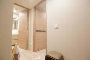 a hallway with a wooden door in a room at shirokane apartment Vx in Tokyo