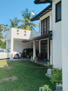 een huis met een auto ervoor geparkeerd bij Colombo Villa Near Bolgoda Lake 5 Bed 2.5 Bath in Piliyandala