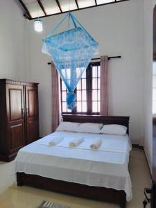 a bedroom with a large bed with a blue net at Colombo Villa Near Bolgoda Lake 5 Bed 2.5 Bath in Piliyandala