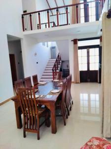 a dining room with a wooden table and chairs at Colombo Villa Near Bolgoda Lake 5 Bed 2.5 Bath in Piliyandala