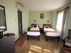 a hotel room with two beds and a television at The Luxe Inn Boutique Hotel in Kathmandu