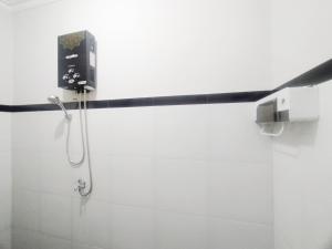 eine Dusche im Bad mit einem Telefon an der Wand in der Unterkunft RedDoorz Syariah Near Stasiun Purwokerto in Purwokerto