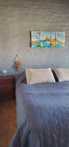 1 dormitorio con 1 cama con 2 cuadros en la pared en Grace’s House, Ezeiza Airport en Monte Grande