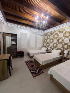 - une chambre avec 2 lits et un lustre dans l'établissement Asia Central Boutique, à Boukhara