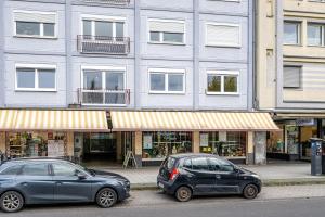 dois carros estacionados em frente a um edifício em NEU: 100m² - ideal für Familien/Geschäftsr. - HBF em Koblenz