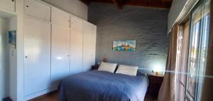 Un dormitorio con una cama azul y una ventana en Grace’s House, Ezeiza Airport en Monte Grande