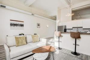 uma sala de estar com um sofá branco e uma mesa em CozySuites - 2BR with Direct Skybridge Access #5 em Indianápolis