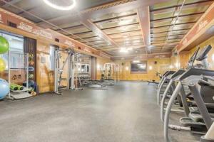 a gym with treadmills and machines in a room at CozySuites - 2BR with Direct Skybridge Access #5 in Indianapolis