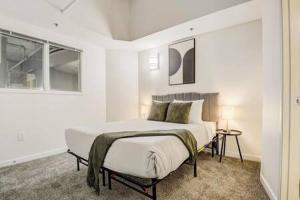 a white bedroom with a bed and a window at CozySuites - 2BR with Direct Skybridge Access #7 in Indianapolis +37 photos