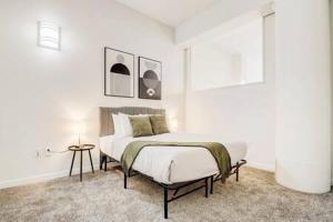 a white bedroom with a bed and a table at CozySuites - 2BR with Direct Skybridge Access #7 in Indianapolis