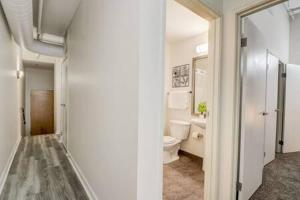 a white bathroom with a toilet and a sink at CozySuites - 2BR with Direct Skybridge Access #7 in Indianapolis