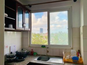 een keuken met een raam boven een wastafel en een aanrecht bij A calm stay with free WiFi in Dar es Salaam