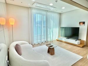 uma sala de estar com um sofá, uma televisão e uma mesa em Stay G7 Busan Station em Busan