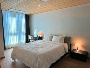 1 dormitorio con 1 cama blanca grande y escritorio en Stay G7 Busan Station en Busan