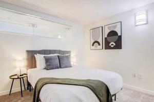 a white bedroom with a large bed in a room at CozySuites - 2BR with Direct Skybridge Access #10 in Indianapolis