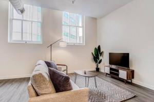 a living room with a couch and a tv at CozySuites - 2BR with Direct Skybridge Access #10 in Indianapolis