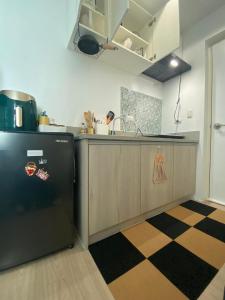 a kitchen with a black refrigerator and a counter at Primo's Crib-The Linear Makati in Manila