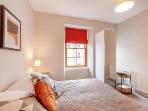 sypialnia z łóżkiem i oknem w obiekcie Castlegate w mieście Jedburgh