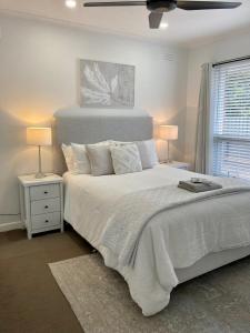 a bedroom with a large white bed with two lamps at Rosa's Apartment in Mount Gambier