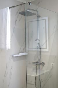 a shower with a glass door in a bathroom at Tūristu apartamenti in Sigulda