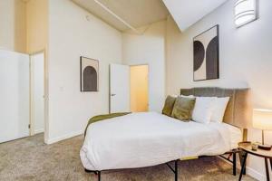 - une chambre avec un grand lit blanc et une table dans l'établissement TWO CozySuites Apartment with Skybridge Access #2, à Indianapolis