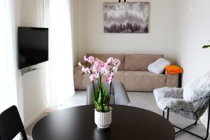 ein Wohnzimmer mit einem Tisch und einer Blumenvase darauf in der Unterkunft Tūristu apartamenti in Sigulda