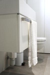 bagno bianco con servizi igienici e asciugamano. di Tūristu apartamenti a Sigulda