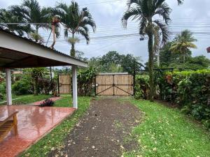 a backyard with a gate and palm trees at Hijos del Bosque in Bijagua