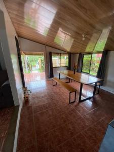 a living room with a wooden table and windows at Hijos del Bosque in Bijagua