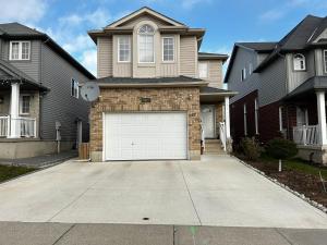 a house with a white garage door in a driveway at Comfortable room C in Kitchener