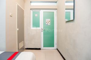 einen Flur mit Tür in einem Zimmer in der Unterkunft J&B Rooms Utan Kayu Jakarta Mitra RedDoorz in Jakarta