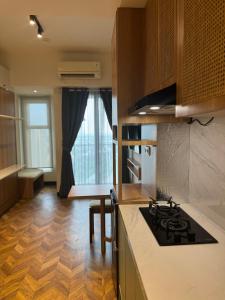 a kitchen with a stove and a counter top at Studio Amor Apartemen Pakuwon City Mall in Surabaya