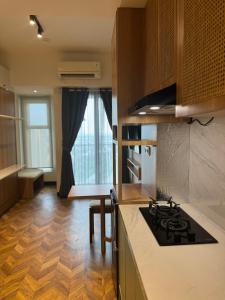 a kitchen with a stove and a counter top at Studio Amor Apartemen Pakuwon City Mall BACA DESKRIPSI in Surabaya