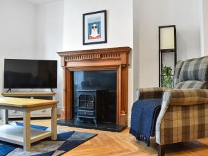 een woonkamer met een open haard en een televisie bij Grey Gull in Whitby