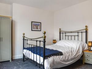 een slaapkamer met een zwart bed en een blauwe deken bij Grey Gull in Whitby