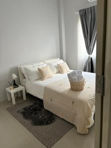 a white bedroom with a bed with a basket on it at House near the beach in Nai Yang Beach