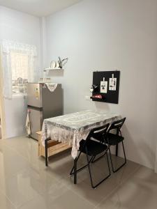 a kitchen with a table and two chairs and a refrigerator at House near the beach in Nai Yang Beach