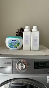 three bottles of detergent sitting on top of a microwave at House near the beach in Nai Yang Beach