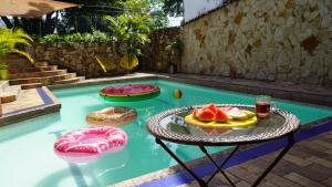 uma piscina com uma mesa com um prato de fruta em Casa Arq em Cali