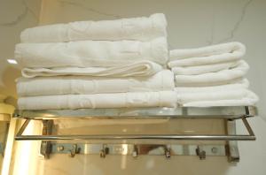 a stack of white towels on a rack in a bathroom at Gia Kiên Hotel in Quy Nhon +90 photos