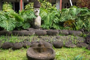 a statue of a head sitting in a garden at Hotel Hotu Matua by EI in Hanga Roa