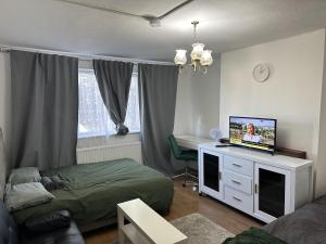 a bedroom with a bed and a tv on a dresser at Great 5-Bed Wembley Home 25min from Central London in London