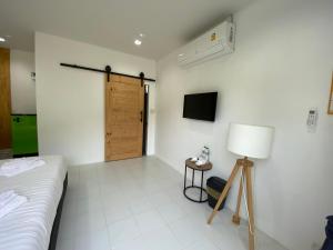 een slaapkamer met een bed, een lamp en een deur bij 65 hostel chiangmai in Chiang Mai