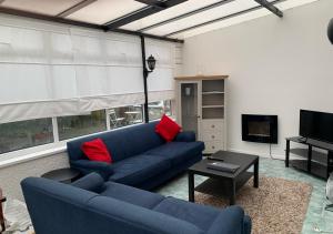 uma sala de estar com um sofá azul e almofadas vermelhas em The Cross - Y Groes em Oxwich