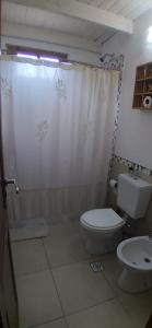 y baño con aseo y cortina de ducha. en CASONA PINTORESCA en las sierras en San Roque