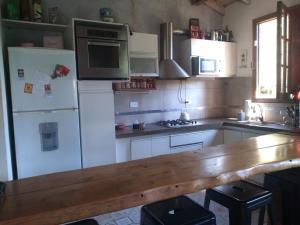 a kitchen with white appliances and a wooden counter top at CASONA PINTORESCA en las sierras in San Roque