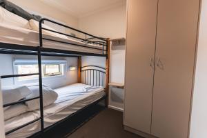 a bedroom with two bunk beds and a closet at BIG4 St Helens Holiday Park in St Helens