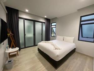 65 hostel chiangmai في شيانغ ماي: غرفة نوم بسرير ابيض ونافذة