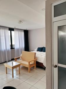 a bedroom with a bed and a chair and a table at Habitacion privada Lamat I in San Pedro La Laguna